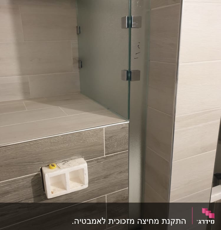 זכוכית חלבית עם צירים מתכתיים על קיר אריחים